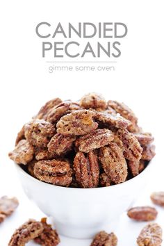 a white bowl filled with candied pecans sitting on top of a table