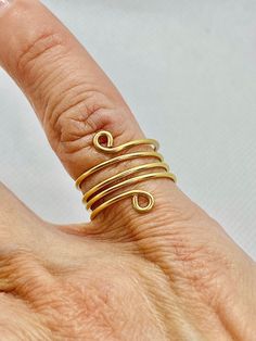 This lovely and stylish gold tone spiral statement ring makes a great gift! I have skillfully handmade this spiral ring with 18-gauge tarnish resistant gold tone wire. It is adjustable and looks great on.   If you would like this ring made with 14kt gold filled wire please message me. The price will be higher, and I will quote you a price before you buy it  All rights reserved: EdnasBeadBox and ArtByEdna on YouTube. Please follow me on social media. It really helps me because I take great care i Adjustable Spiral Gold Midi Rings, Gold Spiral Bypass Ring As Gift, Adjustable Gold Bypass Ring Gift, Adjustable Gold Bypass Ring As Gift, Adjustable Gold Toe Bypass Ring, Spiral Ring, Please Follow Me, 14kt Gold, Statement Ring