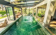 an indoor swimming pool surrounded by glass walls