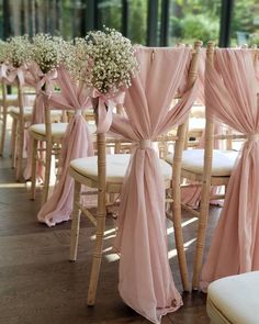 wedding chairs with pink sashes and baby's breath flowers