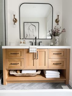 a bathroom with a large mirror and wooden cabinets