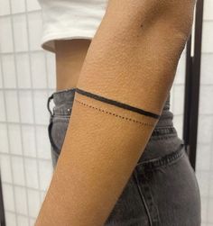 a woman's arm with a small black line tattoo on the left side of her arm