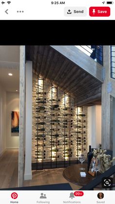 a room filled with lots of bottles of wine on top of a wooden floor next to a stair case