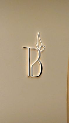 the letter b is made out of metal and has a leaf on it's side