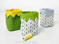 three small baskets with different designs on them, one is green and the other is blue