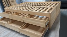 a wooden bed with drawers on top of it