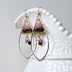 "Ready made. Clusters of individually wrapped tourmaline teardrops swing prettily below rows of tiny, sparkling tourmaline rounds. The golden marquise hoops have been hand-forged and hammered by myself. ~ tourmaline ~ gold filled wire, ear wires, and chain ~ 2 3/4 inches (7 cm), from the top of the ear wire to the bottom of the hoop; the hoops are 1 1/4 inches (3.2 cm) across ~ choose between French ear wires or lever backs (see the last picture) ~ POSTS: Gold filled posts are also available. Se Handmade Tourmaline Dangle Jewelry, Tourmaline Teardrop Gemstone Earrings, Teardrop Tourmaline Gemstone Earrings, Handmade Tourmaline Green Earrings, Handmade Tourmaline Dangle Earrings, Handmade Green Tourmaline Earrings, Wire Jewelry Rings, Marquise Earrings, Beaded Earrings Diy