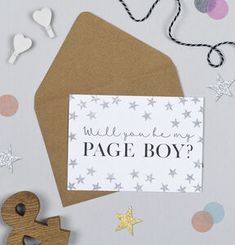 a card with the words will you be my page boy? on it next to a wooden toy