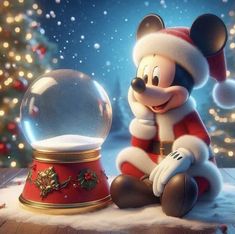 a mickey mouse sitting in front of a snow globe