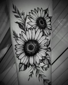 a sunflower tattoo on the arm with leaves and flowers in black and white ink