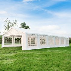 a large white tent set up in the middle of a field with windows on each side