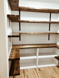 an empty room with shelves and wooden flooring