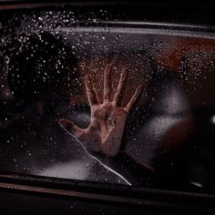 a person's hand sticking out of a car window with rain drops on it