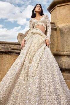 a woman in a white dress standing on a ledge