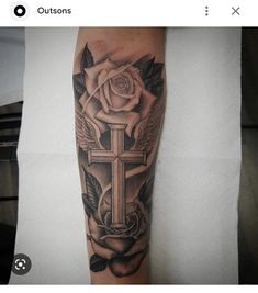 a cross and roses tattoo on the arm