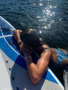 a woman laying on top of a surfboard in the water