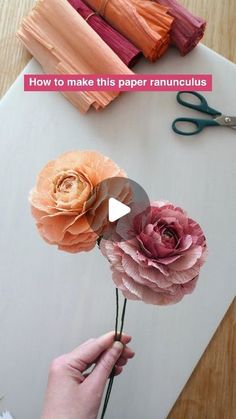 someone is cutting paper flowers with scissors