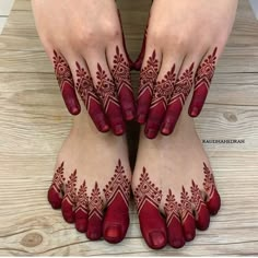 two hands with henna tattoos on their feet, one is red and the other is white