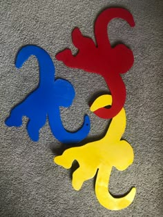 three different colored wooden shapes sitting on the floor