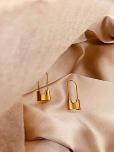 Introducing our captivating and stylish Lock-Shaped Long Earring in stunning shiny gold - a unique accessory that effortlessly merges fashion with a touch of intrigue. Elevate your ensemble with this statement piece that not only adds a dash of sophistication but also reflects your bold and confident style. Crafted with attention to detail, this earring features a meticulously designed lock-shaped charm, cast in radiant gold. The lustrous finish catches and reflects light, ensuring that you'll be the center of attention wherever you go. The elongated design adds a touch of drama, making it perfect for both casual and formal occasions. The secure hook closure ensures a comfortable fit, allowing you to wear this earring with confidence throughout the day or night. The lightweight design ensu Shaped Hoop Earrings, Pad Lock, Long Earring, Confident Style, Earring Sale, Modern Earrings, Style Earrings, Jewelry Earrings Hoops, Accessories Unique