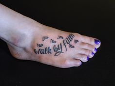 a woman's foot with the words walk by faith written on it and paw prints