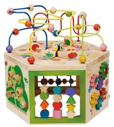 a box with beads and toys in it sitting on a glass shelf next to a white wall