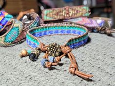 Bead Loom Leather Wrap Bracelet Blue Green Feather Blanket Boho Bracelet Bohemian Jewelry Aerieanna's Wristcraft This is a bead loom leather wrap bracelet made with naturally dyed (veggie) golden brown leather from the USA.  The beads are shades of green and blue. The button is brass plated pewter in a beaded flower design. Glass and stone dangles with feather charm. This bracelet closes at about 7 1/4" and 8 1/4". Adjustable Turquoise Bohemian Wrap Bracelet, Adjustable Bohemian Turquoise Wrap Bracelet, Adjustable Bohemian Wrap Bracelet, Bohemian Adjustable Hand Wrapped Leather Bracelet, Bohemian Adjustable Leather Bracelet For Festival, Adjustable Turquoise Wrap Bracelet For Festival, Multicolor Beaded Spiritual Leather Bracelet, Adjustable Bohemian Leather Bracelet For Festival, Handmade Blue Wrap Bracelet