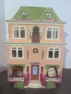 a pink doll house sitting on top of snow covered ground