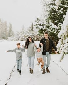 a family is walking through the snow together