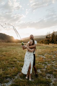 two people standing in a field holding each other