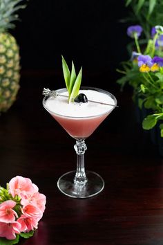 a drink in a glass on a table with flowers