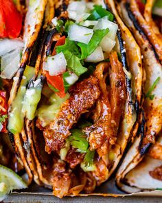 an assortment of tacos with meat, vegetables and sauce