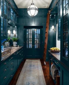 a kitchen with green painted walls and wooden floors, along with an area rug on the floor