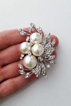 A pearl brooch is a decorative piece that accents and forms the shape of a neckline. A Pearl brooch is also known as a corsage pin. This brooch is a perfect accessory for the fall season. It features a large pearl and leaves with a rhinestones accent. It's the ideal way to add elegance and style to your everyday wear. ⭐   6 cm x 5m that is about 2.4" x 2" ⭐   Lead, cadmium, and nickel free ⭐   Pearl sizes are 14mm and 10mm ⭐   Pearl color is a soft ivory ⭐   Seriously unique for more brooches & pins https://www.etsy.com/shop/okqSupply?ref=seller-platform-mcnav§ion_id=27262035 Bridal Rhinestone Headpiece, Brooch Bouquet Diy, Brooch Corsage, Bridal Brooch Bouquet, Rhinestone Headpiece, Wedding Brooch Bouquets, Corsage Pins, Bridal Accessories Jewelry, Brooch Diy