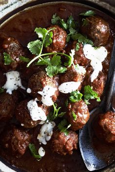 meatballs with sour cream and cilantro in a bowl on a table top