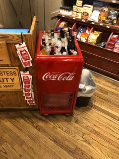 an old coca - cola machine sitting on the floor in a store