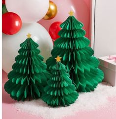 three paper christmas trees in front of a mirror