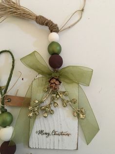 a christmas ornament hanging on a wall next to twine of green and white ornaments