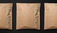 two brown bags with white writing on them sitting side by side in front of a black background