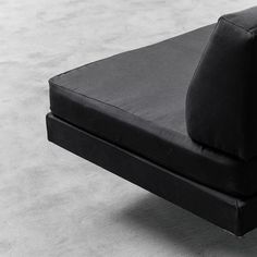 a black couch sitting on top of a gray floor