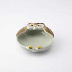 an owl shaped bowl with two yellow eyes