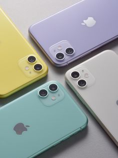 four different colored iphones sitting next to each other on top of a gray surface