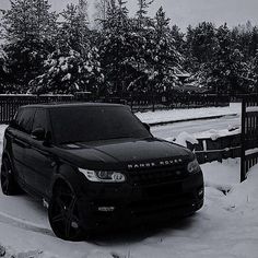 a black range rover parked in the snow