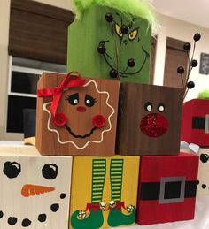 wooden blocks decorated with christmas decorations and faces on top of a white cloth covered table