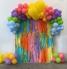 a bunch of balloons and streamers in front of a wall