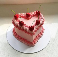 a heart shaped cake with cherries on top