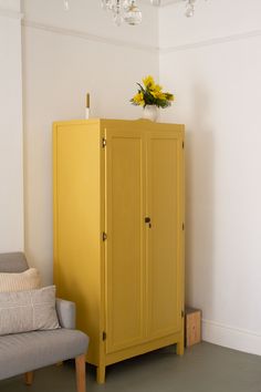 a yellow cabinet sitting next to a gray couch