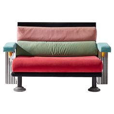 a multicolored couch sitting on top of a black metal frame with four pillows