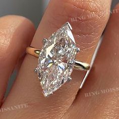 a woman's hand with a ring on it and a large diamond in the middle