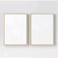 two white paintings hanging on the wall next to each other